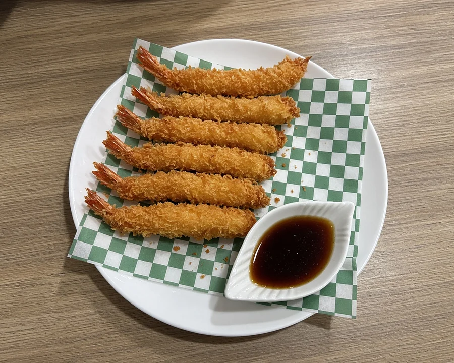 Six panko-fried shrimp with dipping sauce on checkered paper at Hana Sushi, Winnipeg