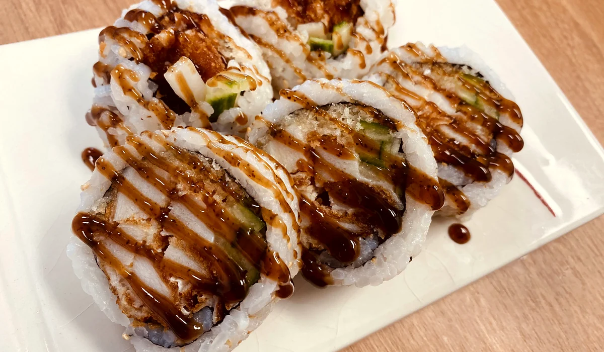 Chicken teriyaki sushi roll drizzled with teriyaki sauce on a white plate at Hana Sushi, Winnipeg
